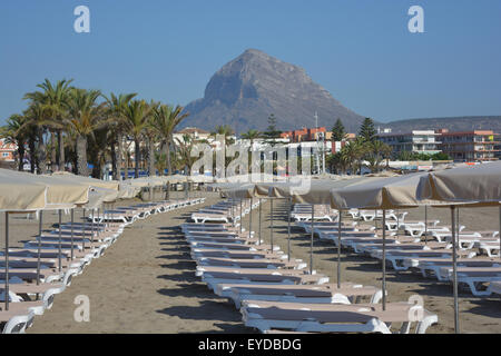 Am frühen Morgen am Arenal Strand von Javea / Xabia, mit Liegestühlen und Sonnenschirmen löschte bereit für die Touristen. Spanien. Stockfoto