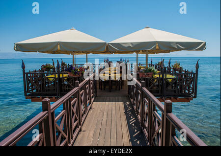 Ein Restaurant auf einem Steg, der sich zum Meer mit wunderschönen venezianischen Stil-Leuchten erstreckt Stockfoto