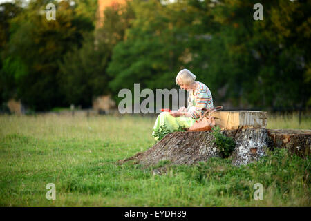 Oma mit ihrem Ipod auf dem Lande. Stockfoto