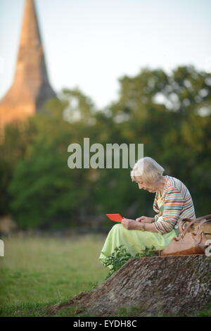 Oma mit ihrem Ipod auf dem Lande. Stockfoto