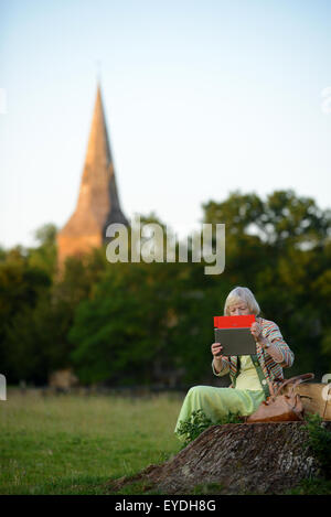 Oma mit ihrem Ipod auf dem Lande. Stockfoto