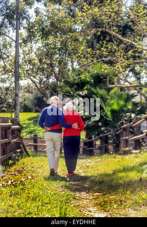 Ein liebevoller älteres Ehepaar gehen gemeinsam auf einem Weg in Lake Forest, Kalifornien. Stockfoto