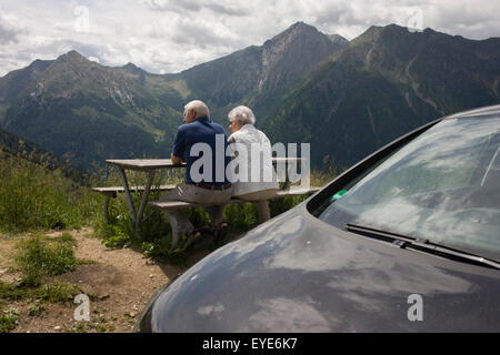 Ältere Besucher bewundern die Aussicht von der Straße im oberen Bereich der Jaufenpass, der höchste Punkt auf 2.094 Meter auf der Straße zwischen Meran-Meran und Sterzing-Sterzing in Südtirol, Italien. Stockfoto