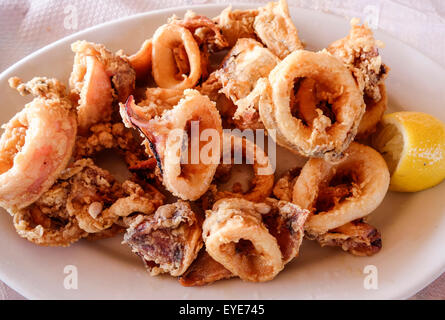 Griechische Küche. Gebratene Kalamari. Frittierte Tintenfischringe mit Keil von Zitrone, Skala Eresou, Lesbos, Griechenland Stockfoto