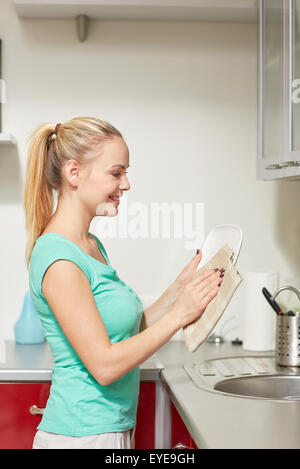 glückliche Frau wischte Gerichte zu Hause Küche Stockfoto