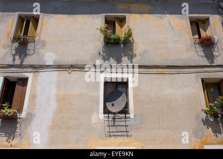 Eine Satellitenschüssel nimmt den Platz von einem italienischen Haus Fenster. Stockfoto