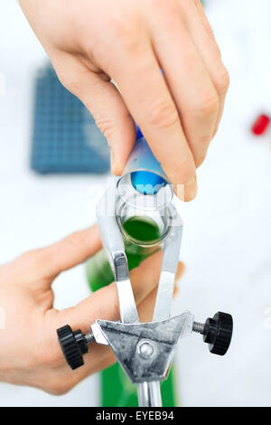 Nahaufnahme der Wissenschaftler füllen Reagenzgläser im Labor Stockfoto