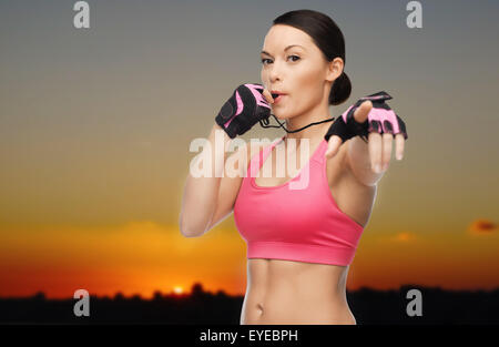 Frau Trainer bläst Pfeife über Sonnenuntergang skyline Stockfoto