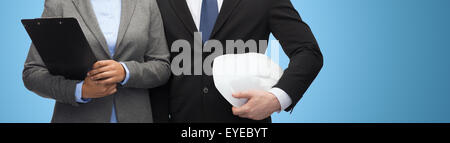 Geschäftsleute mit Zwischenablage und Helm Stockfoto