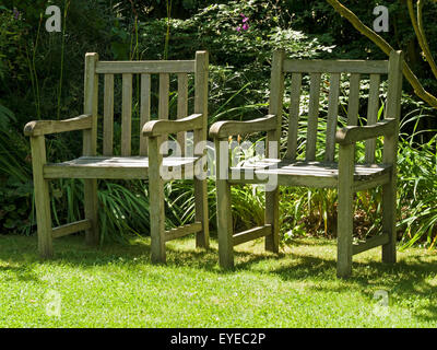 Zwei sonnigen, hölzerne Garten sitzen auf Rasen Rasen, Barnsdale Gärten, Rutland, UK. Stockfoto