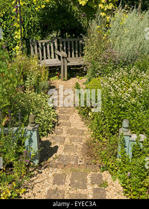 Kleinen englischen Cottage-Garten mit gepflasterten und Kiesweg, Grenzen und Garten Holzsitze, Barnsdale Gärten, Rutland, England, UK Stockfoto