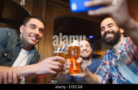 männlichen Freunde mit Smartphone Biertrinken in Bar Stockfoto