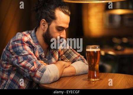 unglücklich einsamer Mann trinken Bier in Bar oder Kneipe Stockfoto