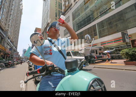 Shanghai, China. 28. Juli 2015. Ein Zusteller trinkt Wasser auf einer Straße in Shanghai, Ost-China, 28. Juli 2015. Die maximale Temperatur von Shanghai am Dienstag erreichte 38,4 Grad Celsius. © Ding Ting/Xinhua/Alamy Live-Nachrichten Stockfoto