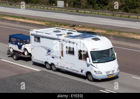 Wohnmobil Frankia-Luxus-Klasse mit einem Anhänger nach Süden auf der Autobahn Stockfoto