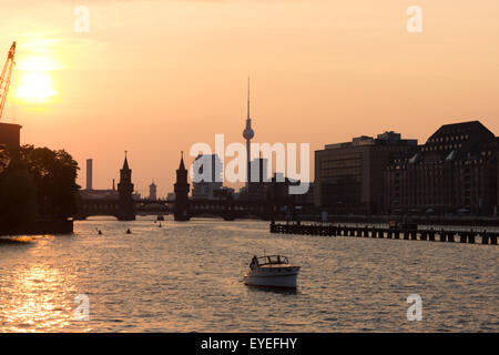 Sonnenuntergang über Berlin, Kreuzberg - Spree mit Boot, Oberbaum-Brücke und tv-Turm Stockfoto