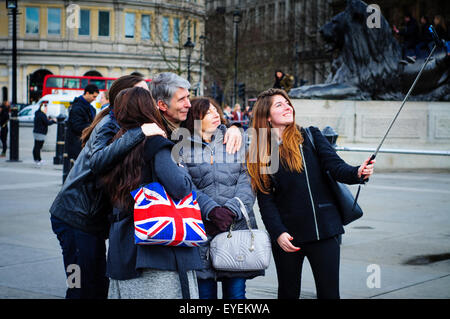 Eine Familie, die Selfies mit Selfie Stick, Trafalgar Square, London, UK Stockfoto