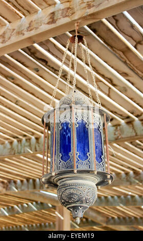Staubige alte Straßenlaterne in arabischem Stil an der Decke unter einem hölzernen Baldachin Stockfoto