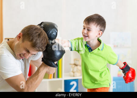 Kind und Papa spielen Boxen Stockfoto