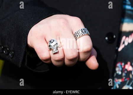 Ein Mann mit einer 'Biker' Ring an seine geballte Faust. Seine anderen Ring ist ein Schädel mit der Ace of Spades gekennzeichnet. Sowohl aus weißem Metall sind Stockfoto