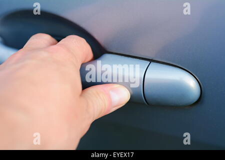 Mans Hand den Griff und blaues Autotür zu öffnen. Stockfoto