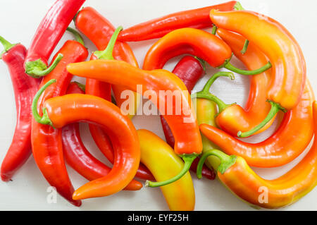 Frisch gewaschen krumm orange und rote Paprika auf einem weißen Holztisch Stockfoto