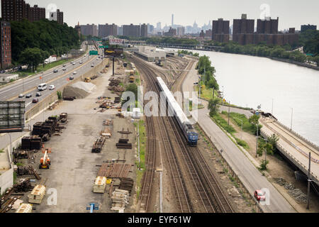 Eine Metro-North-s-Bahn fährt neben dem Harlem River in der Bronx in New York auf Samstag, 25. Juli 2015. Der Major Deegan Expressway parallelen die Eisenbahn an diesem Standort. (© Richard B. Levine) Stockfoto