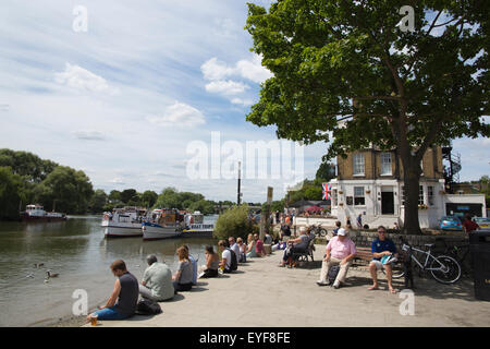 Leute sitzen am Ufer der Themse, Richmond Upon Thames, größere London, UK Stockfoto