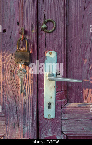 Schloss auf eine alte lila Tür öffnen Stockfoto