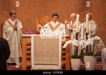 Eine vietnamesische Amerikaner, die Priester von einem Bischof (rechts) und ein Monsignore (links) feiert die Messe in einer Laguna Niguel, CA, katholische Kirche unterstützt wird Stockfoto