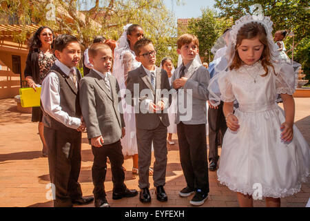 Tragen formale Erstkommunion Outfits, einer Gruppe von Rassen Kinder versammeln sich im Innenhof des Laguna Niguel, CA, katholische Kirche für Erstkommunion feiern. Stockfoto