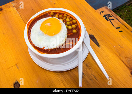 Bohnen mit Spiegelei obenauf in einer würzigen Tomaten basiert-Sauce mit Nudeln, aus Indien Stockfoto