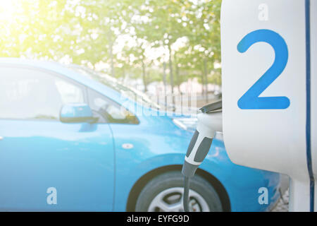 Elektro-Auto an einer Tankstelle in der Straße aufgeladen wird Stockfoto