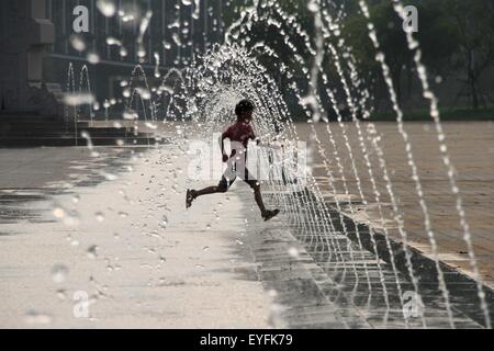 Binzhou, China Shandong Provinz. 26. Juli 2015. Ein Junge genießt kühle in seinen Sommerurlaub an einem Brunnen in Binzhou, Ost-China Shandong Provinz, 26. Juli 2015. © Zhang Binbin/Xinhua/Alamy Live-Nachrichten Stockfoto