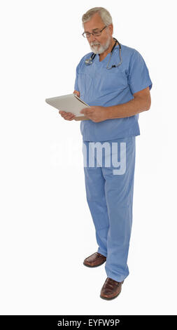 Männlichen Arzt gekleidet in Scrubs Blick auf Tabelle Stockfoto