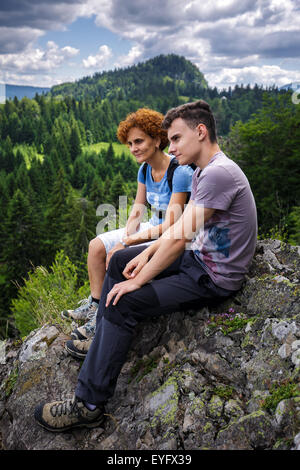 Mutter und Sohn ruht auf einem Berggipfel und die Aussicht genießen Stockfoto