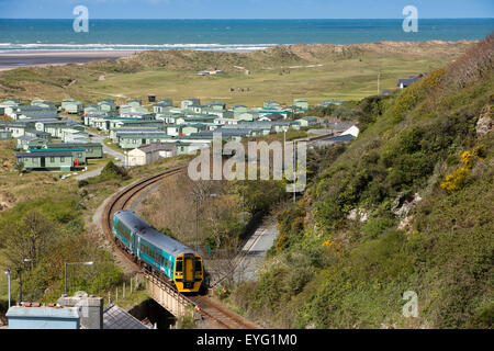 Großbritannien, Wales, Gwynedd, Aberdovey, Cambrian Küste Linie Zug nähert sich Dorf vorbei an Golfplatz und die Dünen Stockfoto