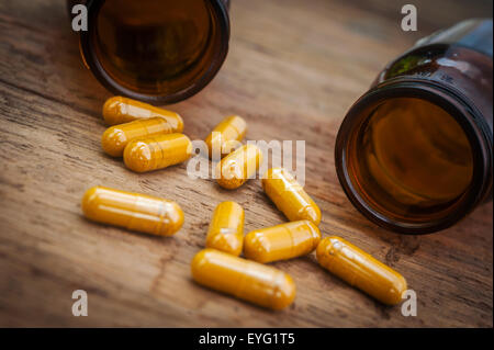 Kraut in Kapsel verschütten aus einer Flasche, Kräuter für Gesundheit, Stillleben und Schatten Stockfoto