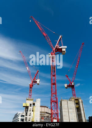 Eine Baustelle mit farbigen hell mobile Baukrane gegen eine lebendige blauen Himmel mit Wolkenfetzen Stockfoto
