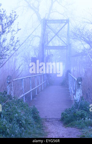 Hängebrücke, umhüllt von unheimlichen Nebel und Nebel am frühen Morgen. Hampshire ist die einzige Hängebrücke auf dem Avon Valley Fußweg. Stockfoto