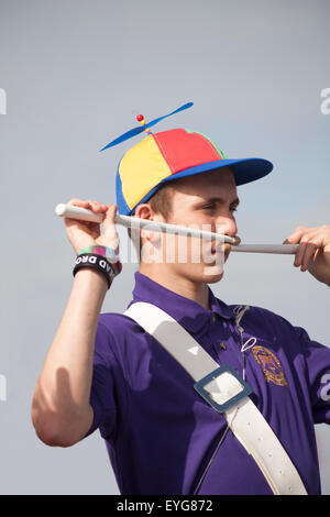 Swanage Karnevalsumzug im Juli mit dem Thema der Superhelden - Schlagzeuger mit Propeller Cap Hut und Drum sticks in den Mund Stockfoto