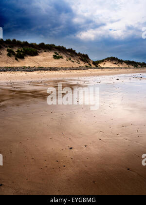 Dunkle Wolken über Sanddünen und nassen Sand am Hauxley Strand schlendern Sie durch das Meer Northumberland England Stockfoto