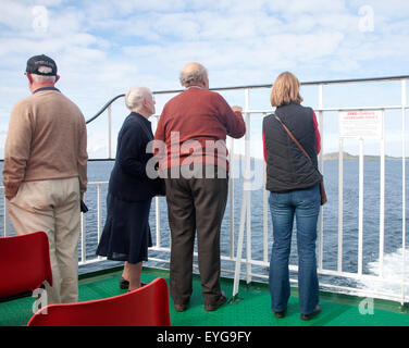 Menschen, die im Rückblick auf die Insel von einem Caledonian MacBrayne Fähre Schiff verlassen Barra, äußeren Hebriden, Schottland, UK Stockfoto