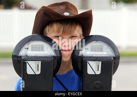 Saint Petersburg, Florida, junge mit Cowboy-Hut von hinten zwei Parkuhren mit Blick Stockfoto