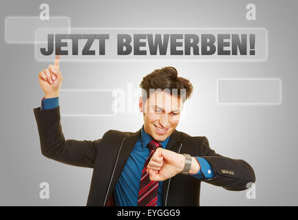 Deutsche Slogan "Jetzt!" (Jetzt bewerben Sie!) mit Business-Mann Überprüfung seiner Uhr Stockfoto