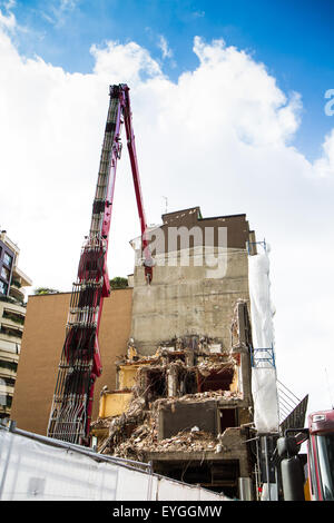 Kran und Bagger arbeiten an Gebäudeabbruch in Städten Stockfoto