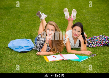 Tennage Studenten auf den Rasen und die Studie zusammen liegen Stockfoto