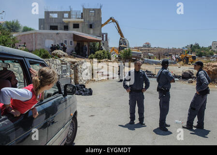 West Bank. 29. Juli 2015. Israelische Polizisten Wache auf dem Gelände, wo illegale Gebäude abgerissen werden, während jüdische Siedler aus ihrem Auto in das Westjordanland Siedlung Beit El am 29. Juli 2015 betrachten. Der israelische Ministerpräsident Benjamin Netanyahu genehmigt Mittwoch Hunderte von neuen Wohnungen in Siedlungen im Westjordanland, inmitten heftigen Reaktion von rechtsextremen Gesetzgeber und Aktivisten auf den Abriss von zwei illegalen Bauten in der Beit El-Siedlung. © Li Rui/Xinhua/Alamy Live-Nachrichten Stockfoto