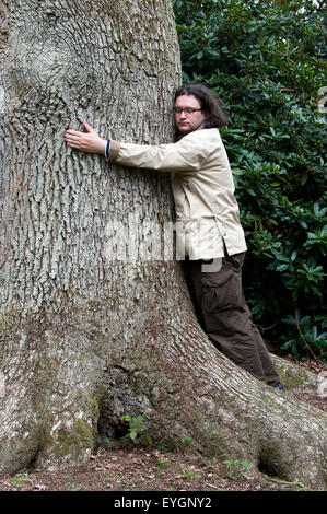 Mann umarmt Grossbaum Stockfoto