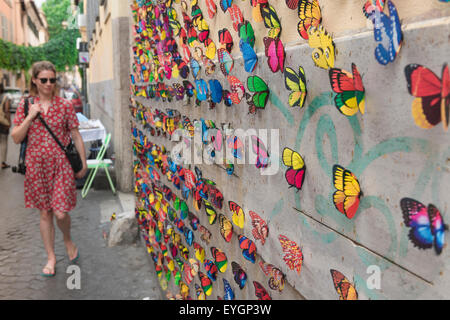 Rom Trastevere Straße, im Markt Trastevere in Rom eine touristische Pässe eine Wand mit einer bunten Papier Schmetterlinge zum Verkauf. Stockfoto